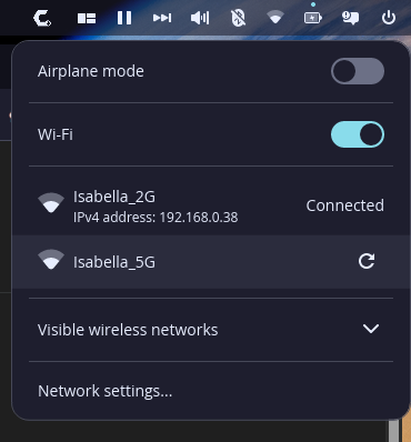 Uma captura de tela de um menu de configurações de rede escura. A parte superior do menu exibe ícones para volume, Bluetooth e configurações de energia. Abaixo, há uma lista de opções de rede.

Modo avião: um botão de alternância está ligado.
Wi-Fi: um botão de alternância está ligado.
Isabella_2G: exibido como conectado, com um endereço IPv4 listado como 192.168.0.38.
Isabella_5G: não conectado.
Visível redes: um menu suspenso com uma seta apontando para baixo.
Configurações de rede: um texto que diz "Configurações de rede..."